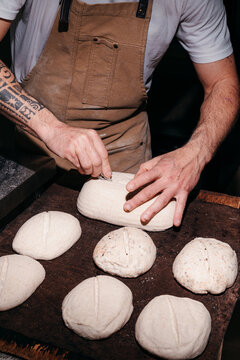 Baker Shapes Dough for Bread in a Bakery at Night