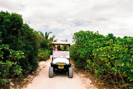 Family on a rented golf cart while on vacation in Bahamas