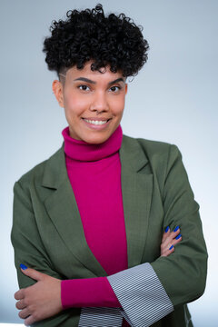 Woman in smart outfit smiles in studio setting
