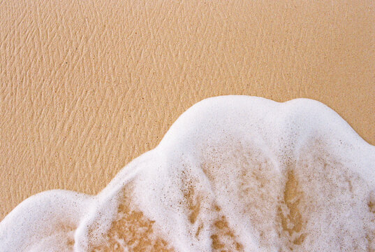Wave rolling onto a sandy beach on 35mm film