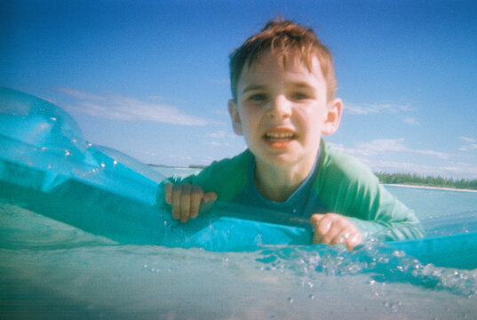 Real family vacation moment of child playing on inflatable raft 