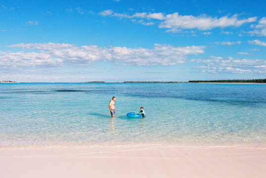 Father and son play together on the beach, vacation in Bahamas