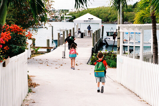 Family leaving vacation on Elbow Cay, Bahamas with suitcases