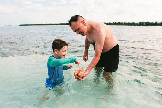 Father and child explore together on a Bahamas beach