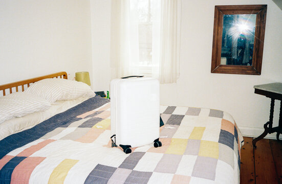 Suitcase on bed at home on film with direct flash