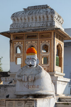 Traditional white guardian statue with orange turban in India