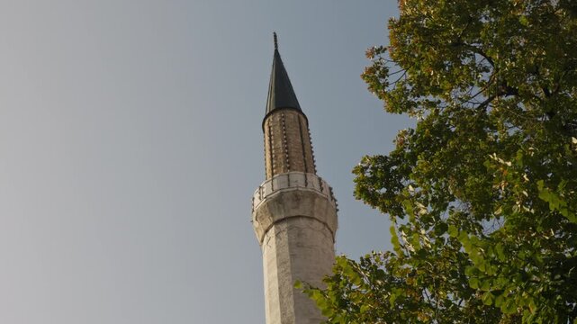 Handheld shot of Gazi Husrev-beg Mosque tower in Saravejo.