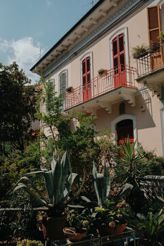 Pastel beige Italian house with red door and shutters