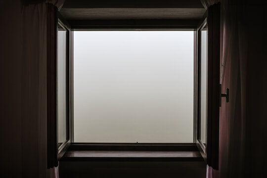 Room with a foggy view. A window wide open but nothing can be seen.