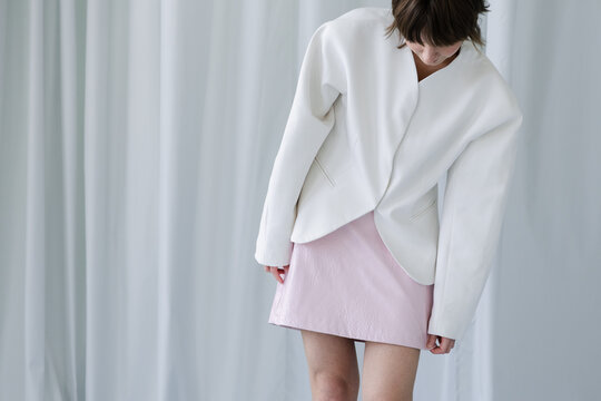Minimal female fashion look with blazer and pastel skirt