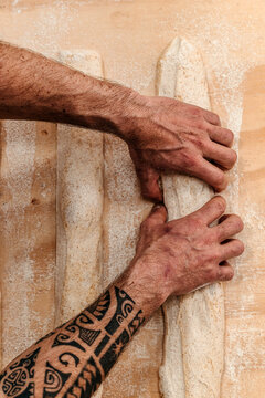Baker Shapes Dough Into Baguettes in a Bakery