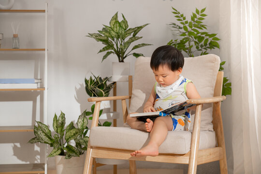 Young child engrossed in reading a book while sitting comfortably