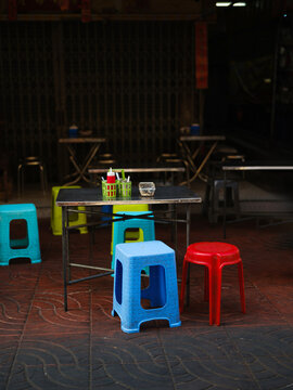 Outdoor street food stall with plastic chairs in Asia 