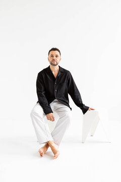 A man sits in a minimalist interior.