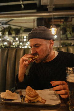 Man enjoying a burger with beer for dinner
