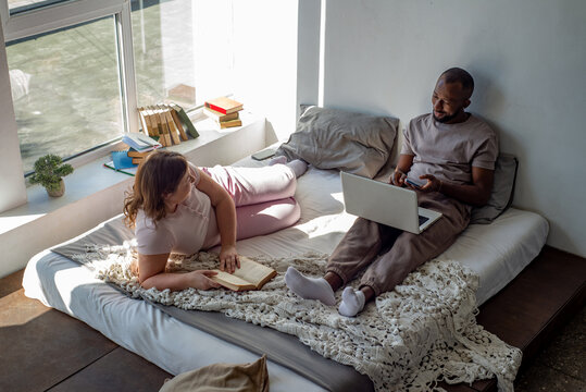 Interracial couple relaxing at home on a bed