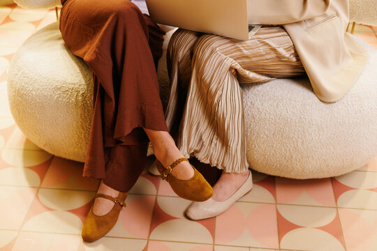 Women Entrepreneurs in Stylish Outfits with Laptop