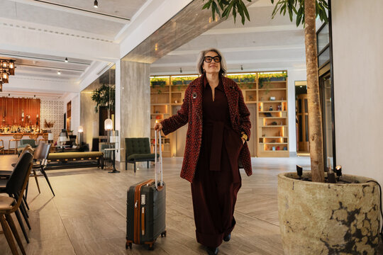 Sophisticated traveler arriving at luxury hotel with luggage