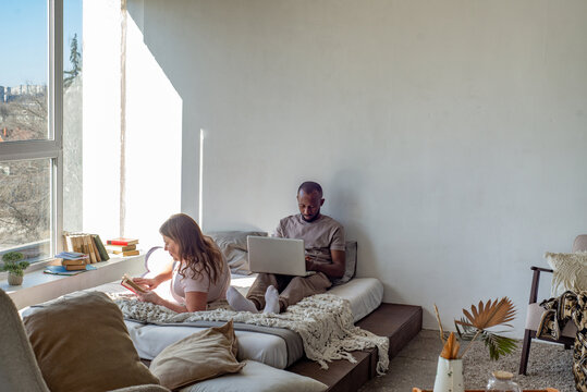 Interracial couple relaxing at home on a bed