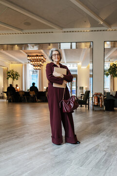 Business professional carrying laptop standing in hotel lobby