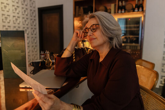 Stylish Senior woman reading menu in a cozy cafe
