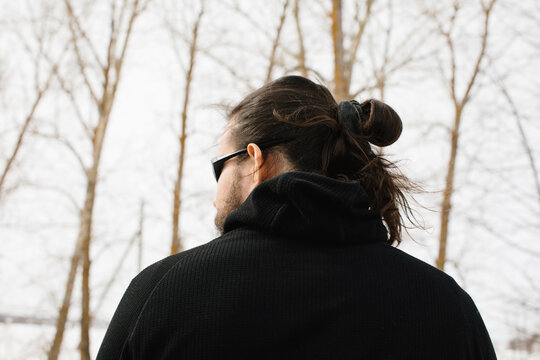 Anonymous man in black with bun