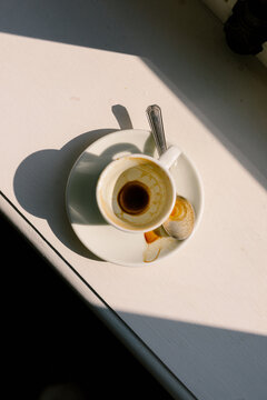 A close-up shot of an empty, used coffee cup  lit by sunlight