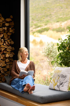 Woman Reading by the Window in a Cozy Space