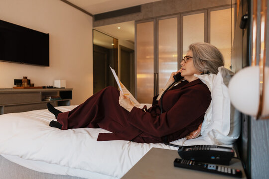 Business traveler talking on telephone in hotel room
