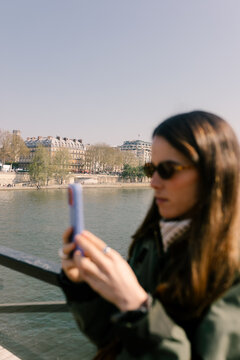 Unfocused tourist photographing the Seine River in Paris