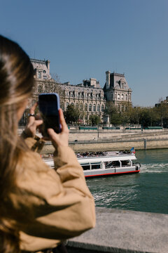 Female tourist using her smartphone to take photos of Paris City Hall