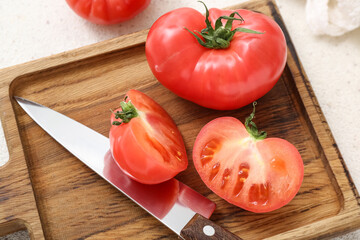 Wooden board with fresh tomatoes on white background