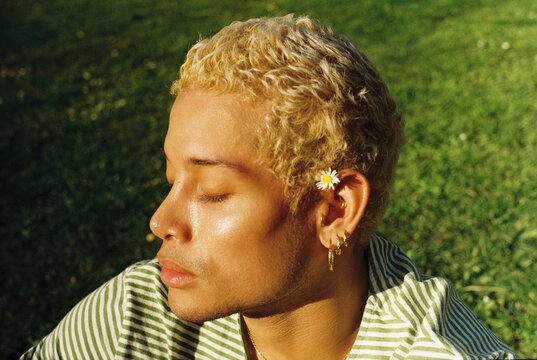 Close-up of man relaxing on grass in sunny park