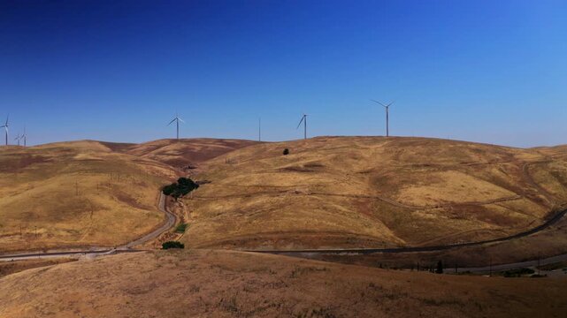 Drone view over wind turbines at the Altamont Pass Wind Farm near Dublin, California. Applicable to clean energy, environmental, and industrial aerial projects