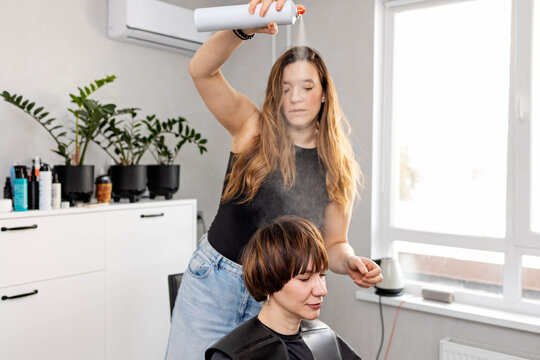 The hairdresser is styling hair.