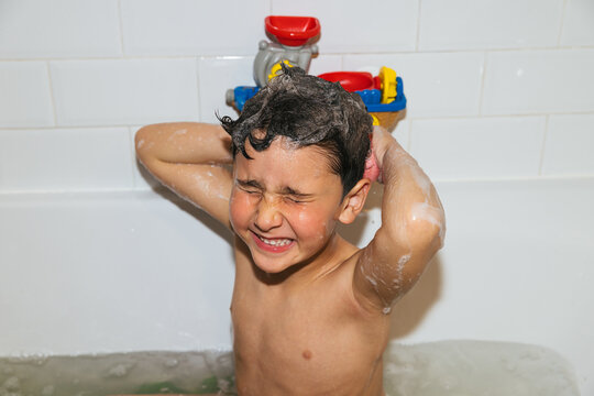 Happy child enjoying fun bubble bath moment at home