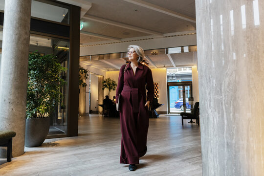 Professional Senior woman inmodern office lobby bringing