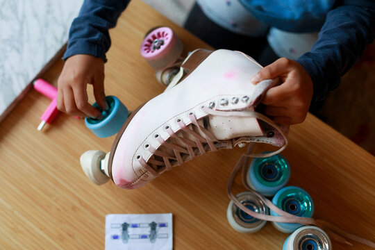 Child Prepares Roller Skates at Home 