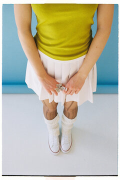 A girl holds a ring while standing and wearing a green top