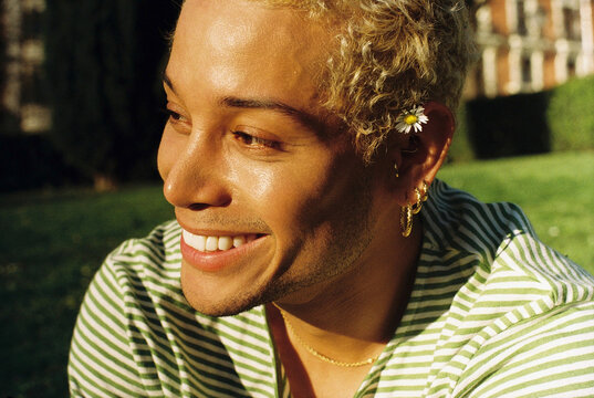 Close-up of man smiling outdoors in sunny park