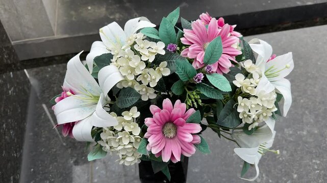 Artificial flower bouquet on grave in cemetery