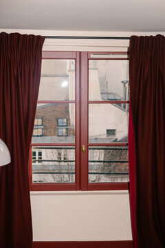 Shot lit by a flash, of a hotel window with a frame and red curtains