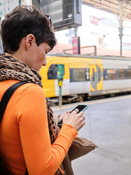 Stylish woman checking smartphone at Sao Bento train station