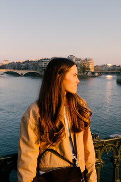 Female tourist posing by the Seine River during sunset