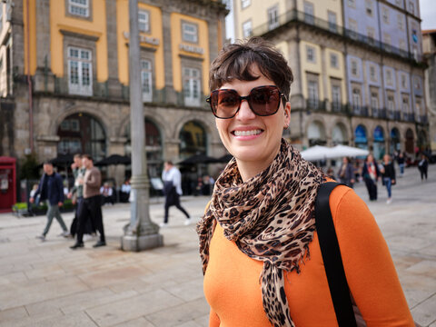 Woman smiling wearing sunglasses and scarf in Oporto