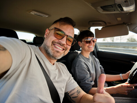 Happy couple driving car on road trip in Oporto