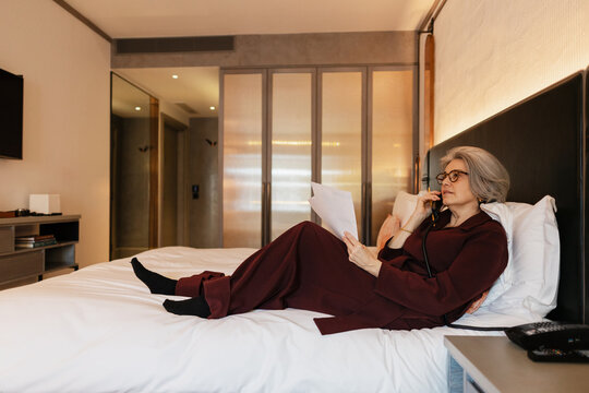 Business traveler using landline phone in hotel room