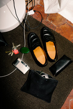 Harsh flash on an extreme close-up of keys, camera, wallet, and shoes.