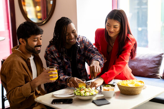 Group of Friends drinking and eating snacks at restaurant