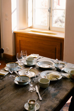 Rustic table lit by natural light with used tableware